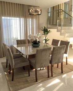 the dining room table is surrounded by beige chairs