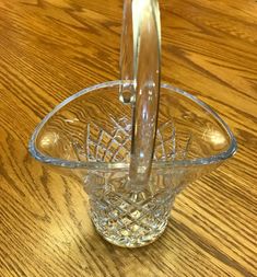 an empty glass bowl on a table with a spoon sticking out of the top,