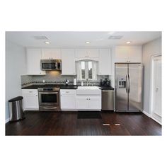 a kitchen with white cabinets, stainless steel appliances and wood floors is shown in this image