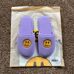 a pair of purple slippers sitting on top of a carpet next to a bag