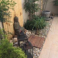 a small garden with rocks, plants and a lantern