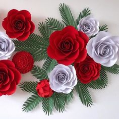 red and white paper flowers arranged on top of each other with pine needles in the middle