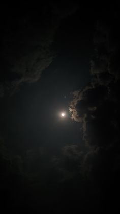 the moon is shining brightly in the dark night sky with fluffy clouds and bright light