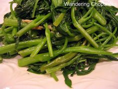 some green vegetables are on a white plate