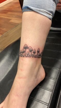 a person with a tattoo on their leg that has mushrooms in the middle of it