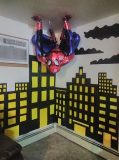 a room decorated with spiderman balloons in the shape of cityscapes and buildings