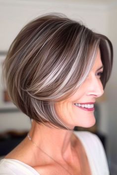 Layered Bob With Silver Highlights Hairstyle on a smiling woman with brown hair and silver highlights. Hide Grey Hair With Highlights Brunettes Short Hair, Brown And Grey Hair Highlights, Gray Hair Color Ideas Over 50, Gray Blending Short Hair, Red Silver Hair, Short Hair Grey Highlights, Brown Hair Going Grey Highlights, Short Brown Bob With Highlights, Mushroom Brown With Highlights