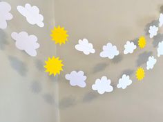 a paper garland with clouds and stars hanging from it