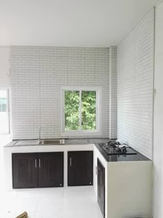 an empty kitchen with black and white cabinets