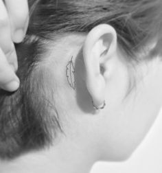 a woman with a small tattoo on her ear