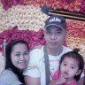 a man and two women standing next to each other in front of a flower wall