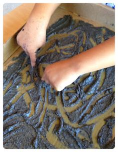 a person is spreading chocolate frosting on top of some brownies in a box