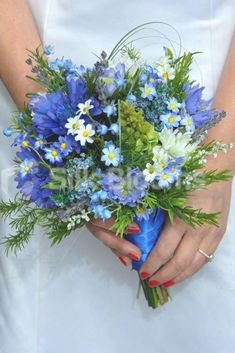 a bride holding a bouquet of blue and white flowers