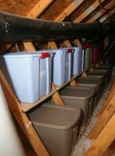 several buckets are lined up in the attic to be used as storage for various items