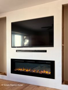 a flat screen tv mounted on the wall above a fireplace