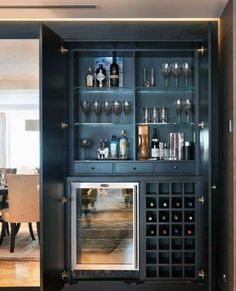 a wine cabinet with many bottles and glasses in it