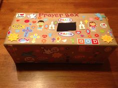 a cardboard box with stickers on it sitting on a table next to a wooden floor