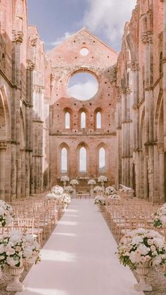 the aisle is lined with white flowers and chairs