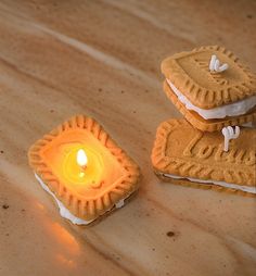 two cookies are sitting on top of each other with a lit candle in the middle