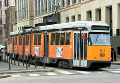 an orange trolley car is on the street