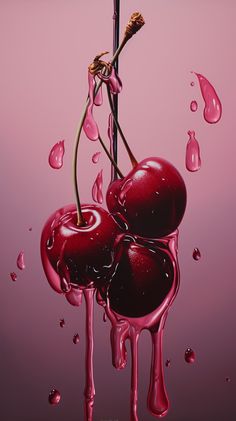 two cherries are dripping in pink liquid