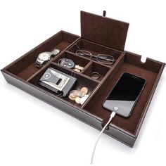 an open briefcase with various items in it and a phone hooked up to the charging cord