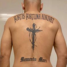 a man with a cross tattoo on his back and the words fortis fortuna adjuita