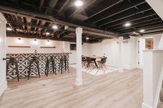 an empty room with bar and stools in the center, surrounded by white walls