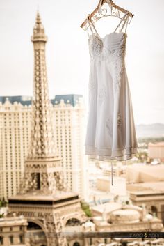 a white dress hanging on a clothes line in front of the eiffel tower