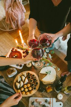 several people are sitting at a table with food and wine