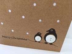 a christmas card with two penguins sitting on a branch