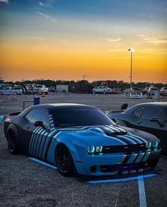 two cars parked in a parking lot at sunset