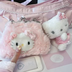 two stuffed animals sitting next to a pink purse