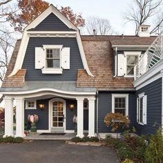 a blue house with white trim and shutters