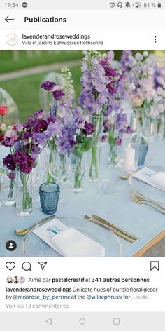 the table is set with purple flowers in vases