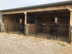 two horses are standing in their stalls at the stable