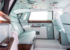 the interior of a luxury car with flowers painted on the ceiling and leather seats,