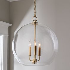 a light fixture hanging from the ceiling in a room with white walls and window sill