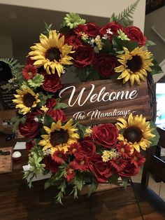 a welcome sign with sunflowers and red roses in the shape of a wreath