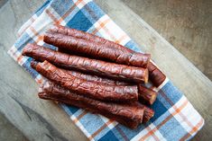 four pieces of sausage on a blue and white checkered napkin