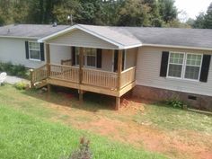 a small house with a porch in the front yard