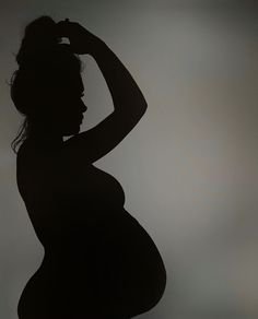 the silhouette of a pregnant woman with her hands on her head