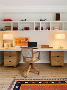 a desk with a chair, lamp and bookshelf