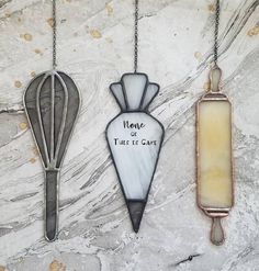 three different colored glass items hanging on a stone wall with the words mane, true it care