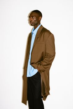 A pared-down sartorial classic with an irreverent twist. This statement structural coat is tailored to perfection with sharp, broad shoulders and clean lines. Constructed in a supremely soft & fluid 100% lightweight wool that drapes below the knee, this layer offers a dose of sophistication to transitional dressing. Oversized Brown Coat, Oversized Aesthetic, Summer Coat, Transitional Dressing, Summer Coats, Broad Shoulders, Brown Coat, Men Fashion Casual Outfits, Men Fashion