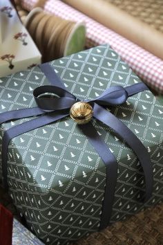 a wrapped present sitting on top of a table next to other wrapping paper and scissors