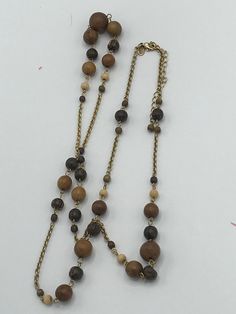 Lia Sophia gold and wood necklace, brown, pearl Elegant Brown Necklace With Gold Beads, Elegant Brown Necklaces With Gold Beads, Elegant Gold Beaded Necklaces With Wooden Beads, Elegant Gold Beaded Necklace With Wooden Beads, Brown Long Beaded Necklace With Wooden Beads, Elegant Long Necklaces With Wooden Beads, Elegant Brown Beaded Chain Necklace, Long Brown Beaded Necklace With Wooden Beads, Elegant Brown Long Necklace With Round Beads