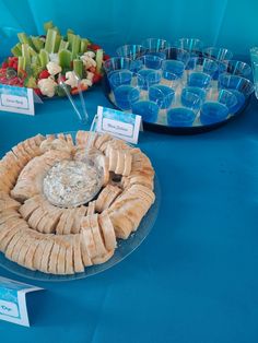 a blue table topped with plates and bowls filled with food