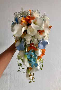 a bridal bouquet with white, orange and blue flowers