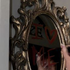 a woman is holding her hands up in front of a mirror with the word love written on it